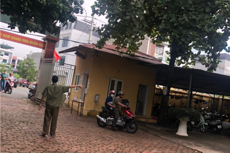 Bác bảo vệ chỉ dẫn cho phụ huynh chỗ để xe và hướng vào tập trung.