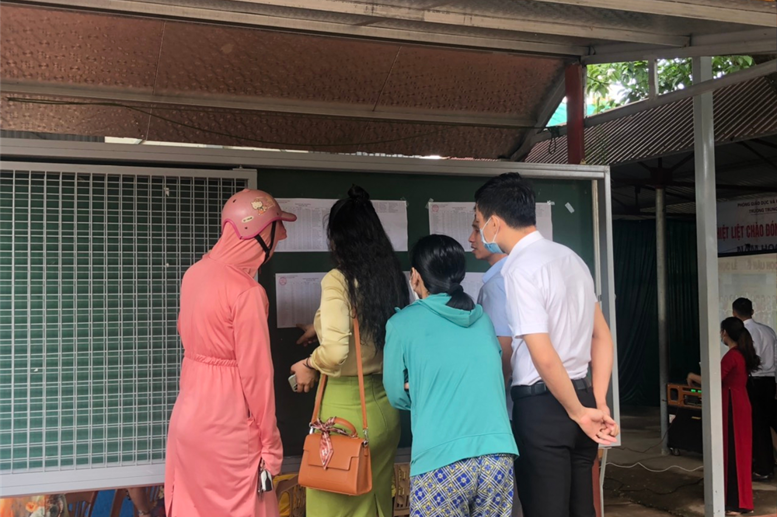 Phụ huynh chăm chú xem danh sách lớp học.