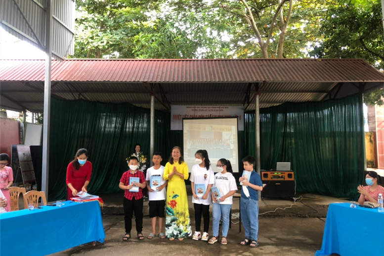 Cô giáo hiệu trưởng kí tặng trao quà cho các em trong phần giao lưu.