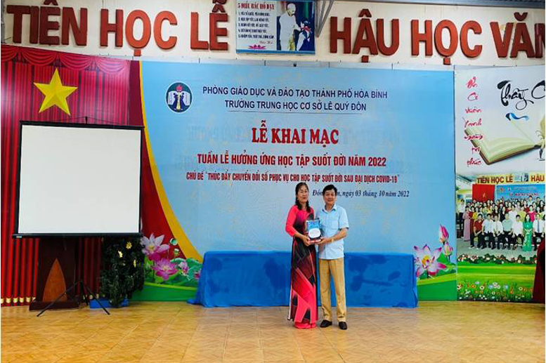 Cô giáo Phạm Thị Hải Châu thay mặt nhà trường nhận sách được trao tặng từ bác Nguyễn Văn Duấn – Trưởng BĐD CMHS nhà trường