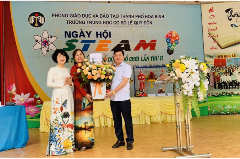 Ông Nguyễn Văn Duấn- Trưởng ban đại diện CMHS nhà trường tặng hoa cho tập thể cán bộ, giáo viên, nhân viên nữ trong nhà trường.