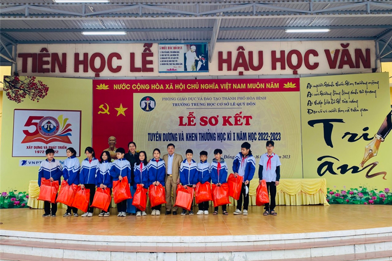 Ông Nguyễn Văn Duấn- Trưởng ban đại diện CMHS nhà trường và cô Ngô Thị Thúy Lan- GV tổng phụ trách đội tặng quà cho 13 em học sinh có hoàn cảnh khó khăn. 