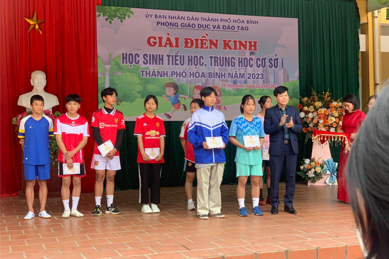 Đồng chí Lê Văn Công- Phó trưởng phòng GD&ĐT TP Hòa Bình trao giải cho em Đặng Minh Hiếu đạt giải Nhì nội dung chạy 100 m Nam.