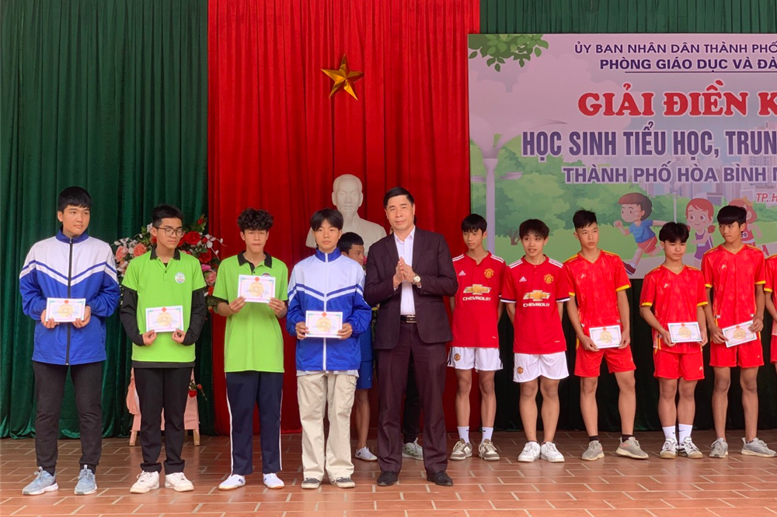 Đồng chí Nguyễn Đức Quế - Phó trưởng phòng GD&ĐT TP Hòa Bình trao giải cho các em trường Lê Qúy Đôn đạt giải Nhì nội dung chạy tiếp sức 4x 100 m Nam.