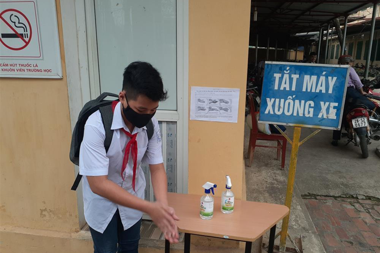 Học sinh được kiểm tra thân nhiệt, đeo khẩu trang và rửa tay sát khuẩn trước khi vào lớp học