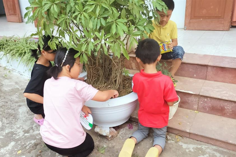 Các em học sinh của hai đơn vị cùng nhau nhổ cỏ, dọn dẹp vệ sinh, gắn kết tình cảm.