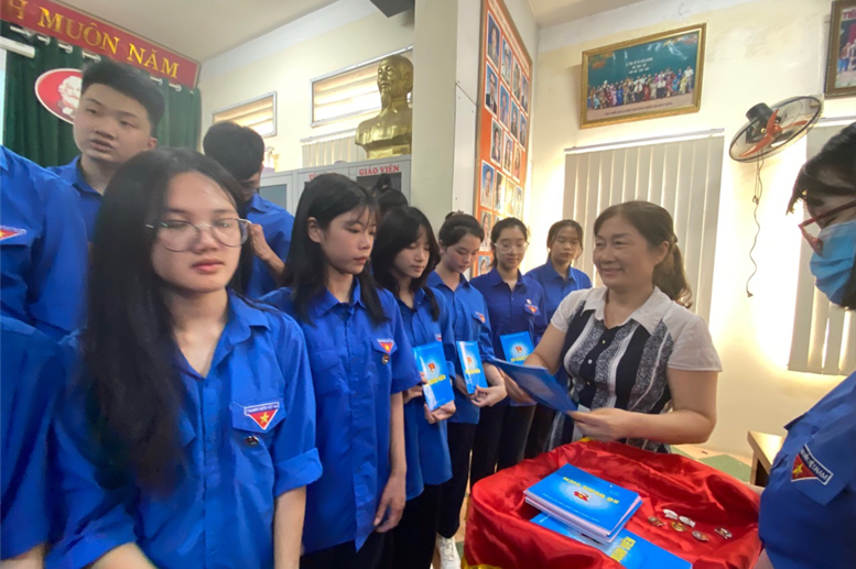 Đồng chí Phạm Thị Hải Châu- Bí thư chi bộ- Hiệu trưởng nhà trường trao huy hiệu Đoàn, sổ Đoàn cho các em.