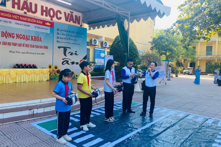 Các em học sinh lớp 6, 7 thực hành đội mũ bảo hiểm đúng cách khi tham gia giao thông