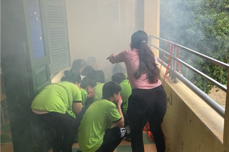 HS được hướng dẫn bịt khăn và cúi thấp người để tránh ngạt khói