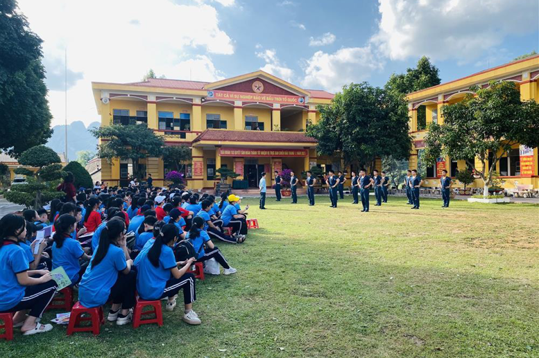 Các em HS chăm chú xem đồng diễn thể dục của các chú bộ đội