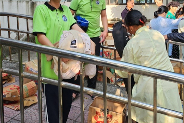 Là chúng em đỡ một bác bệnh nhân, chọn giúp em bé đôi dép và ôm đồ giúp cho một bác đang chọn quần áo cô a!