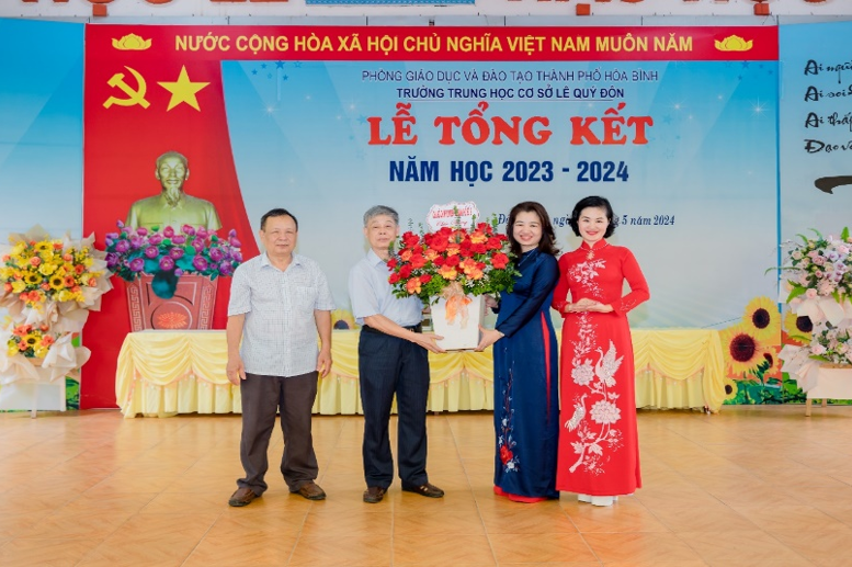 Đại diện Chi bộ tổ dân phố số 2 tặng hoa chúc mừng nhà trường