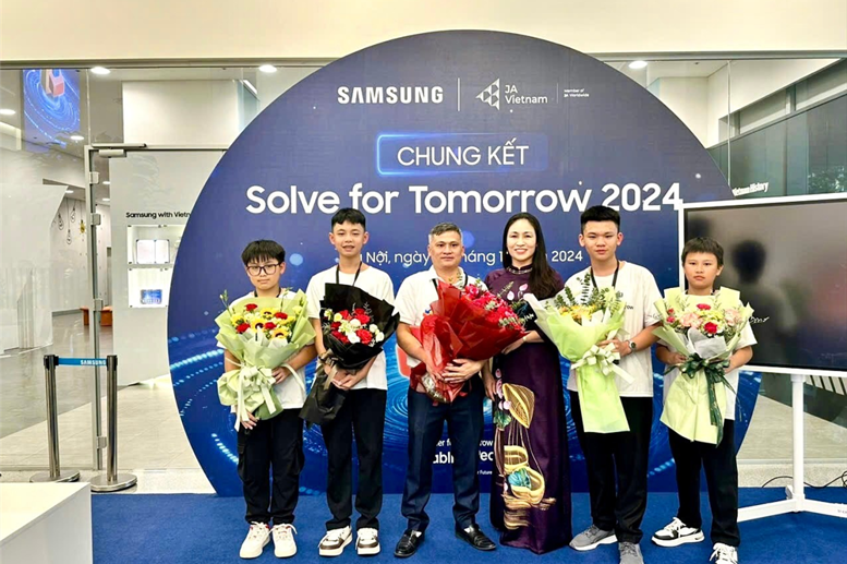 Nhà giáo Vũ Thị Liên - Trưởng phòng GD&ĐT thành phố Hòa Bình tặng hoa và quà chúc mừng thầy trò trong đội thi