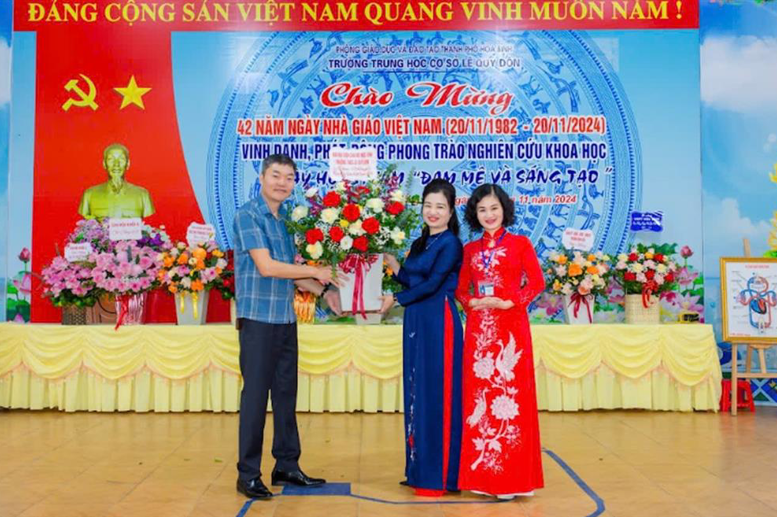 Đại biểu tặng hoa chúc mừng nhà trường