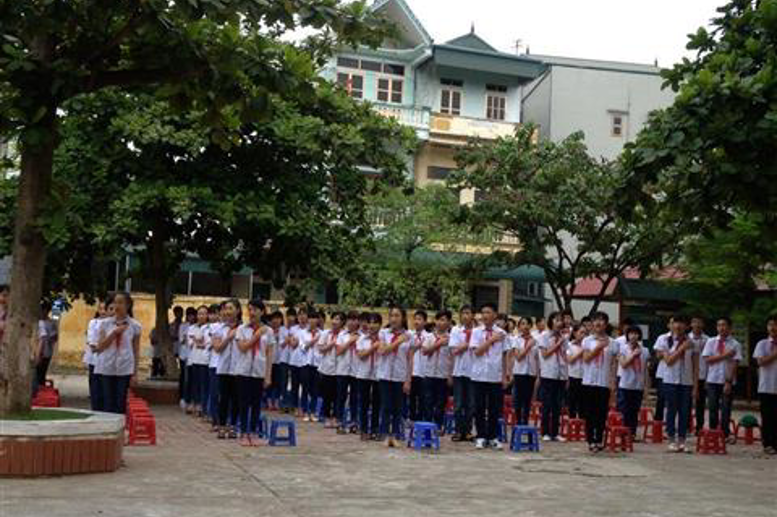 Hình ảnh xúc động trong buổi lễ chào cờ. Học sinh đặt tay lên ngực trái hát quốc ca nhìn cờ tổ quốc