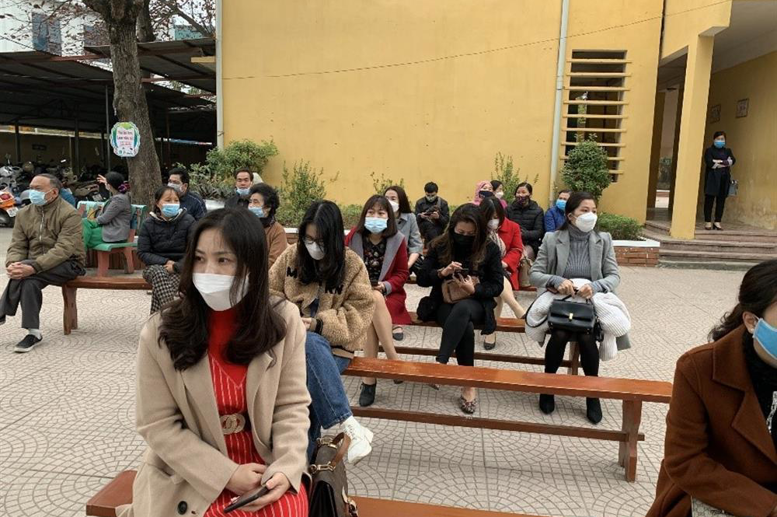 Phụ huynh đưa con đi tiêm chủng.