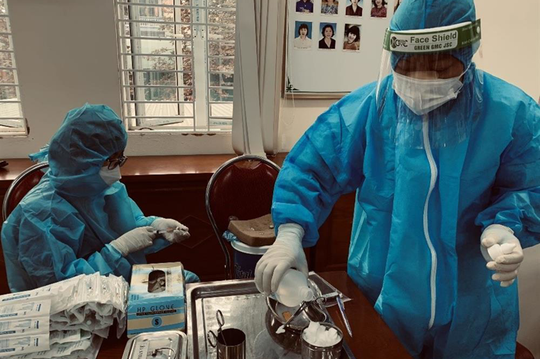 Cán bộ y tế chuẩn bị các liều vắc xin.